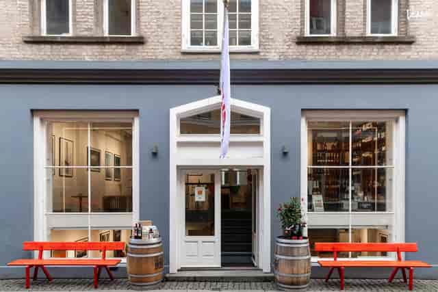 Banquet hall entrance with large windows, rustic barrels, ideal for events and meetings.