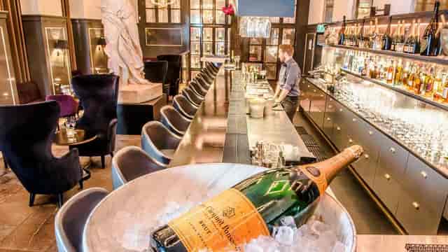 Upscale cocktail venue with sleek bar and champagne, ideal for exclusive gatherings.