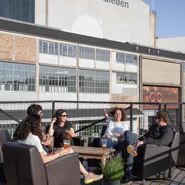 Relaxed networking event on rooftop terrace with casual seating and drinks.