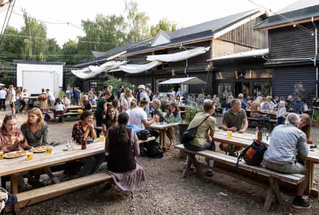 Vibrant outdoor networking event with communal tables and rustic charm in BaneGaarden.
