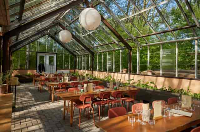 Glass-enclosed dining area at Væksthuset, perfect for intimate gatherings and corporate events.
