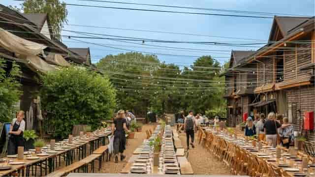 Væksthuset outdoor event space with long tables for summer gatherings or weddings.