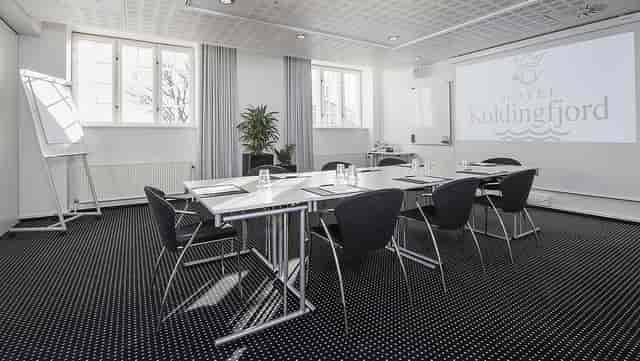 Corporate meeting room at Hotel Koldingfjord with sleek tables, ideal for workshops.