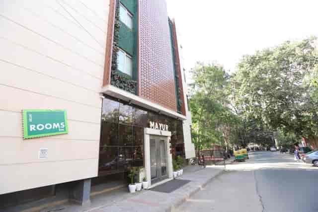 Modern Mayur Hotel entrance with lush greenery, perfect for events and meetings.