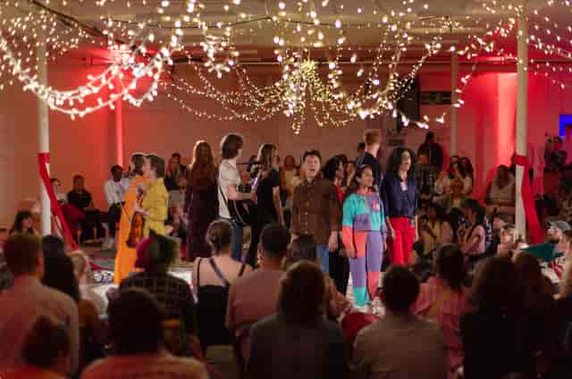 Vibrant SCRUM Studios event space with performers and fairy lights, perfect for gatherings.