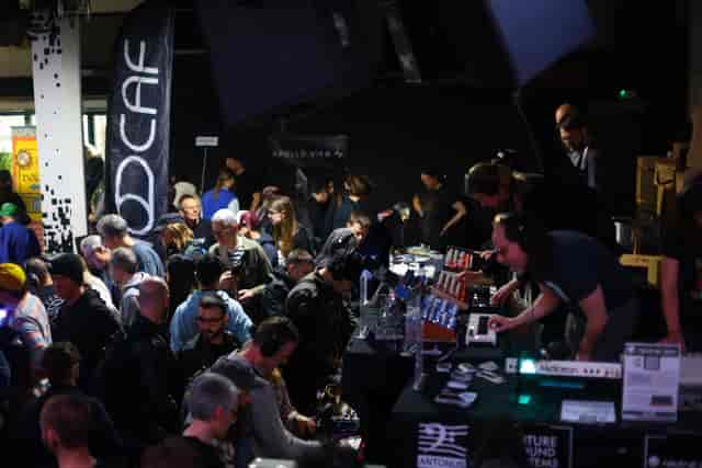 90 Live event in Hackney Wick with attendees networking at tech booths and immersive experiences.
