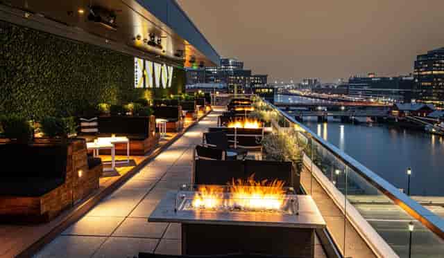 Elegant rooftop terrace venue with fire features, ideal for networking and cocktail events.