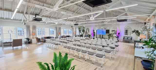 Function room in The Loft with chairs arranged for seminars and modern presentation technology.