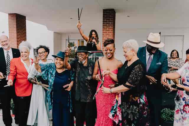 Hogan Brown Gallery ribbon-cutting ceremony with festive attendees celebrating new venue.