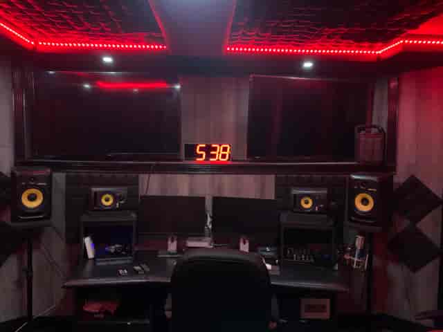 Modern audio-visual control room for hybrid events with dual monitors and studio speakers.