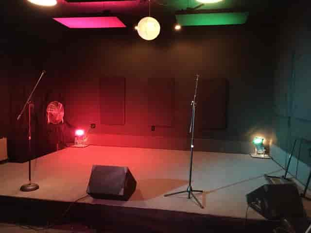 Intimate recording studio with microphones for live performances and vibrant lighting.
