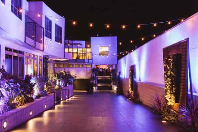 Illuminated outdoor event venue with string lights, ideal for receptions and networking.