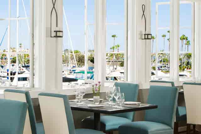 Serene patio dining at BALEENkitchen overlooking marina, ideal for events and networking.
