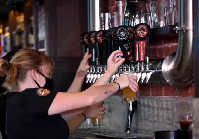 Bartender pouring drinks at The Brews Hall patio, perfect for casual celebrations.