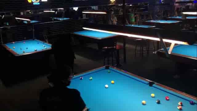 Lively pool hall with neon lights, ideal for networking and team-building events.