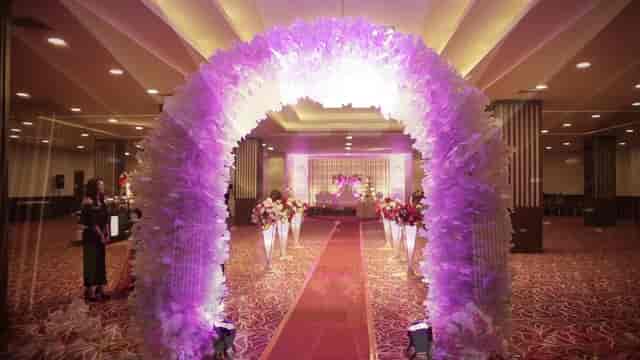 Elegant Crystal Ballroom with floral arch and purple lighting for wedding events.