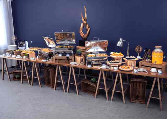 Event planner with buffet setup for corporate event featuring rustic food stations.