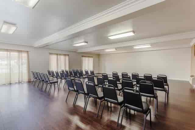 Versatile meeting room with black chairs, ideal for workshops and presentations.