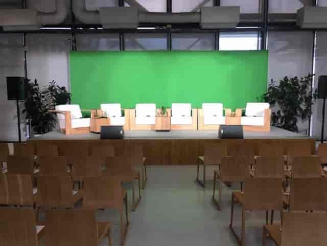 Espace U at Centre Pompidou, modern panel discussion setup with green screen backdrop.