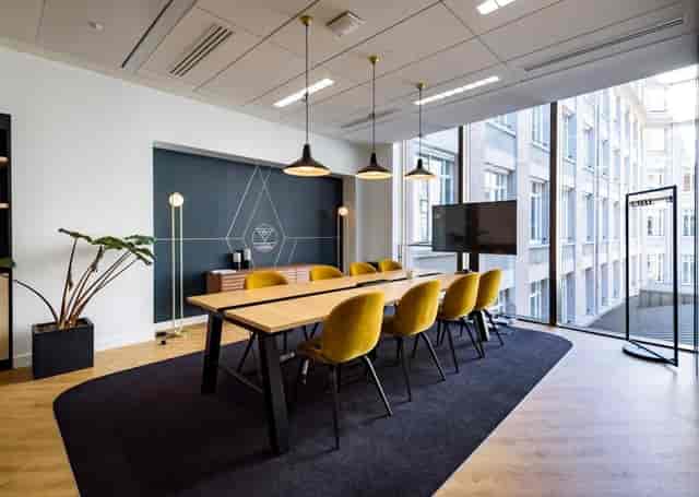 Modern meeting room at Espace Pierre Cardin with yellow chairs for workshops and planning.