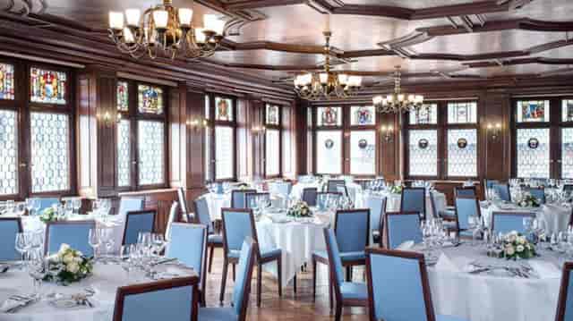 Elegant dining room with round tables for corporate events and formal dinners.