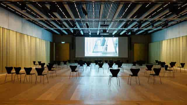 Ballroom in Kunsthaus Zürich: spacious venue with black chairs for workshops and presentations.