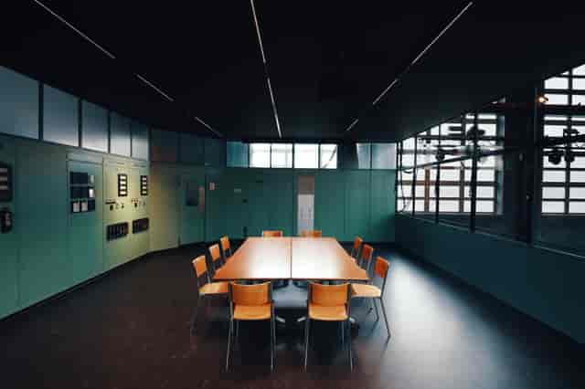 Modern minimalist Kommandoraum meeting room with circular table for workshops and brainstorming.