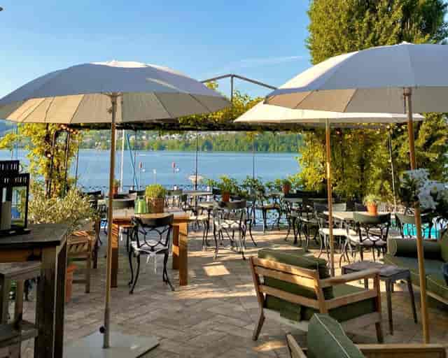 Charming lakeside restaurant with elegant seating for outdoor meetings and events.