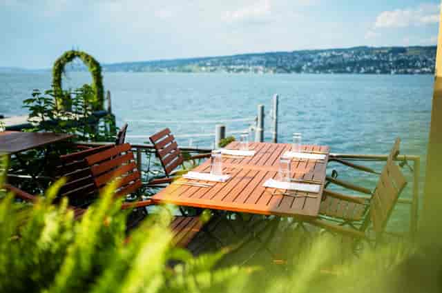 Outdoor dining setup by water at Terrace in Lake Side for summer events and retreats.