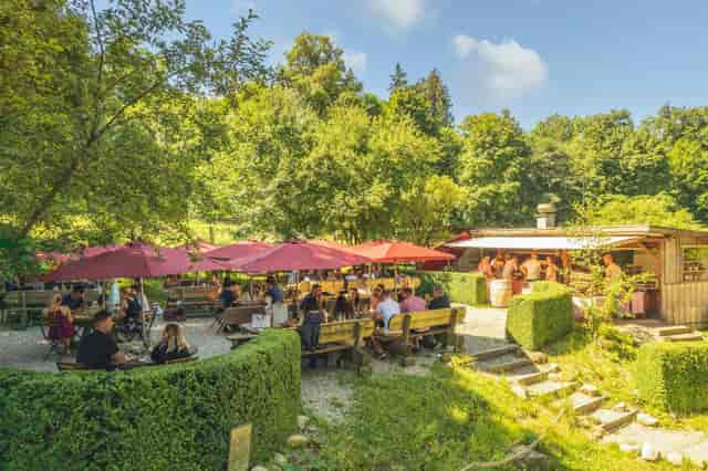 Kuhstall outdoor event space with shaded seating, perfect for summer gatherings and networking.