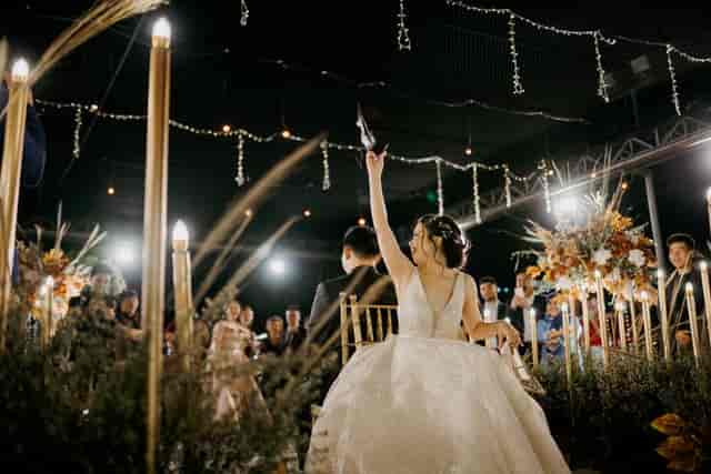 Bride in elegant gown at organized wedding ceremony with floral decor and soft lighting.