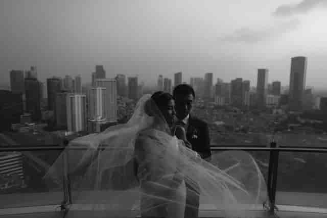 Elegant couple in ballroom with city skyline, perfect for upscale wedding photography.
