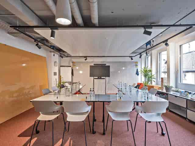 Modern meeting room with glass table, ideal for collaborative brainstorming sessions.