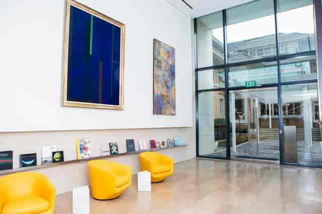Modern library entryway with yellow chairs, ideal for networking events and meetings.