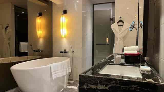 Stylish freestanding bathtub in luxurious hotel bathroom at Sofitel Guangzhou Sunrich.