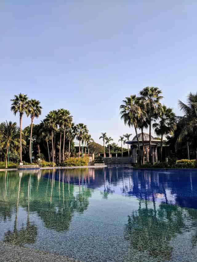 Serene outdoor event space at Nansha Grand Hotel with pool and palm trees.
