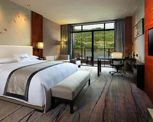 "Luxury hotel suite with large windows, ideal for corporate retreats and meetings."