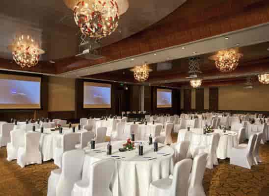 Elegant Champagne Ballroom at Novotel Mumbai for corporate events with round tables.