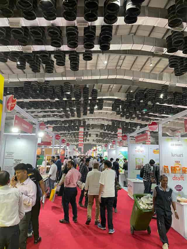 Exhibition hall at Mumbai Center, bustling with attendees on vibrant red carpet.