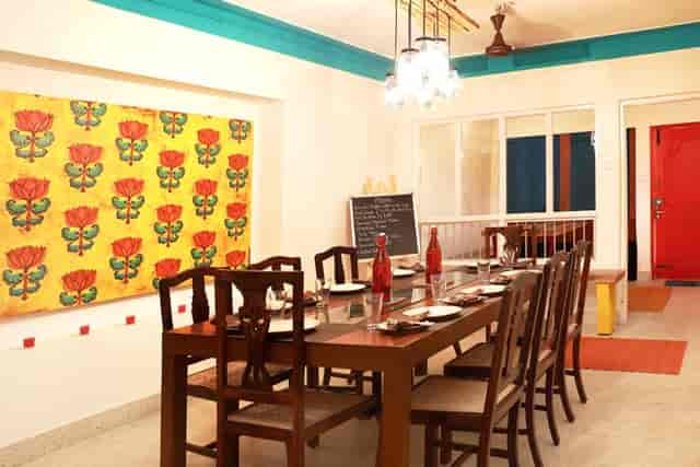 Charming dining area with wooden table for intimate meetings in Bengaluru Oota Company