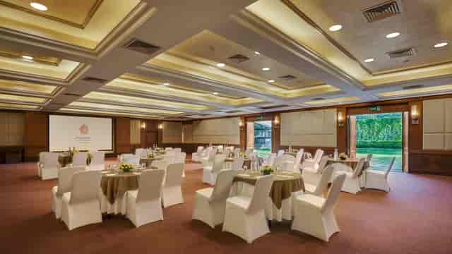 Elegant Burgundy Room set for corporate meeting with round tables and natural light.
