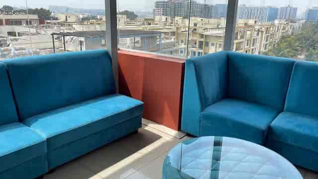 Modern lounge at Raghavendra Arcadian hotel with blue couches, perfect for networking events.