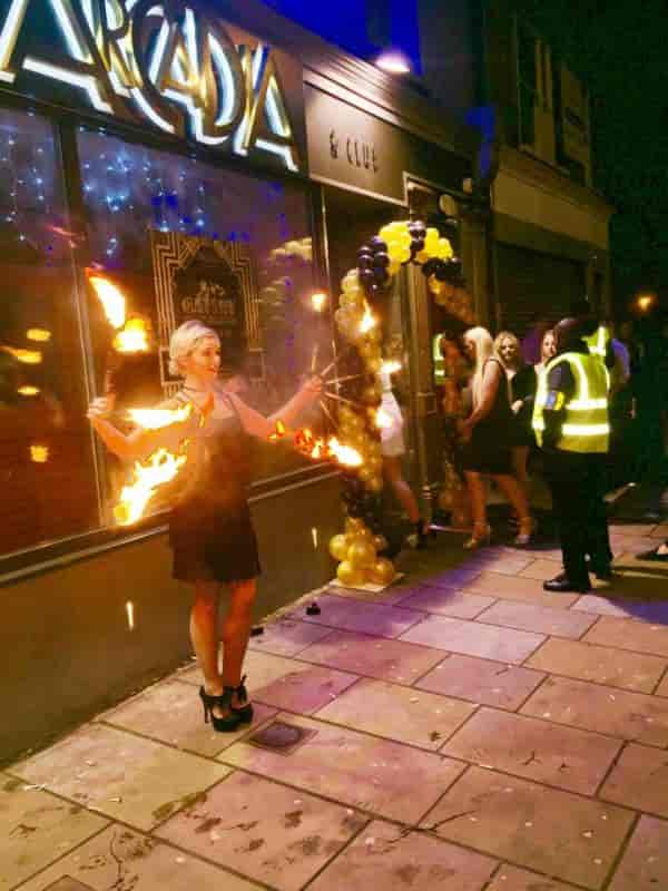 Dramatic fire performer under gold balloon arch at Arcadia Loungebar gala event
