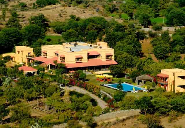 Conference Hall at Royal Retreat Resort & Spa, event venue with lush greenery and pool.
