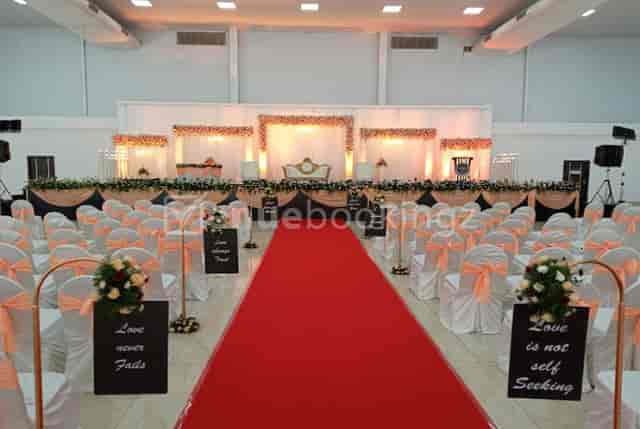 Elegant wedding reception hall with red carpet, chairs, and floral decor at Thee Crystal Palace.