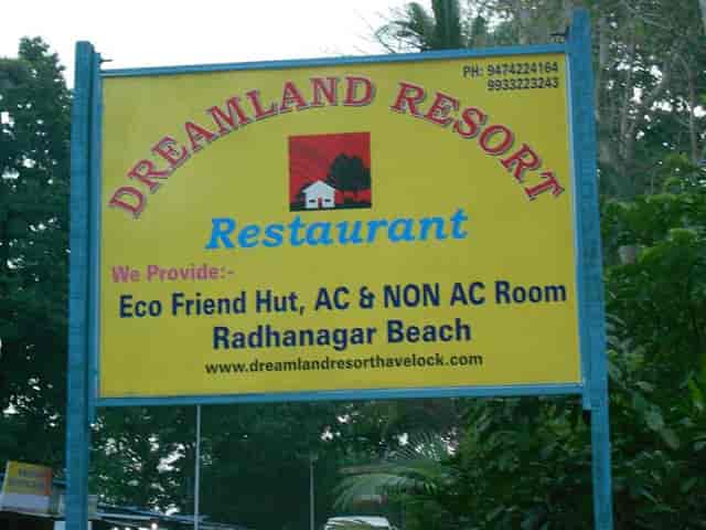 Dreamland Resort sign featuring eco-friendly huts near Radhanagar Beach for retreats.