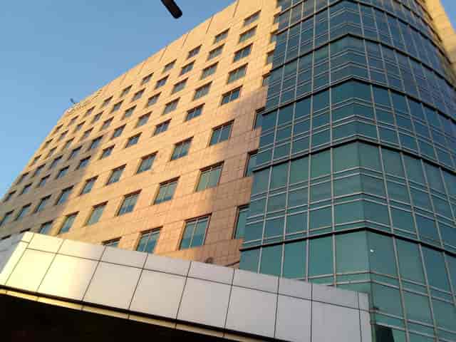 Modern banquet hall in Fortune Hotels, featuring stone and glass architecture for corporate events.