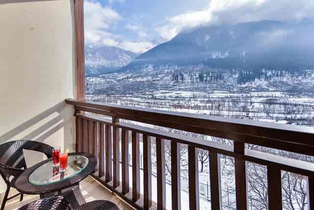 Balcony view hotel retreat in Pahalgam with snow-capped mountains, ideal for corporate events.