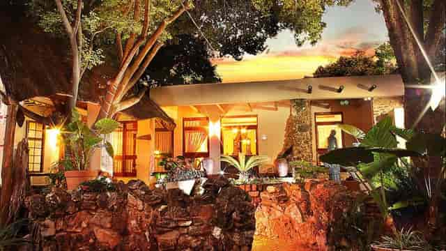 Charming Thatch Chapel Lodge venue with lush greenery for events and gatherings.