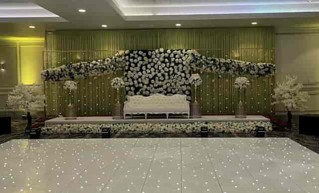 Elegant banquet hall stage with floral backdrop for weddings and upscale events.